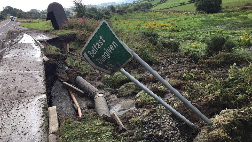 A fallen sign pointing the way to Belfast and Dungiven