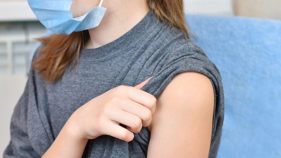 Stock photo girl in face mask waiting for vaccine