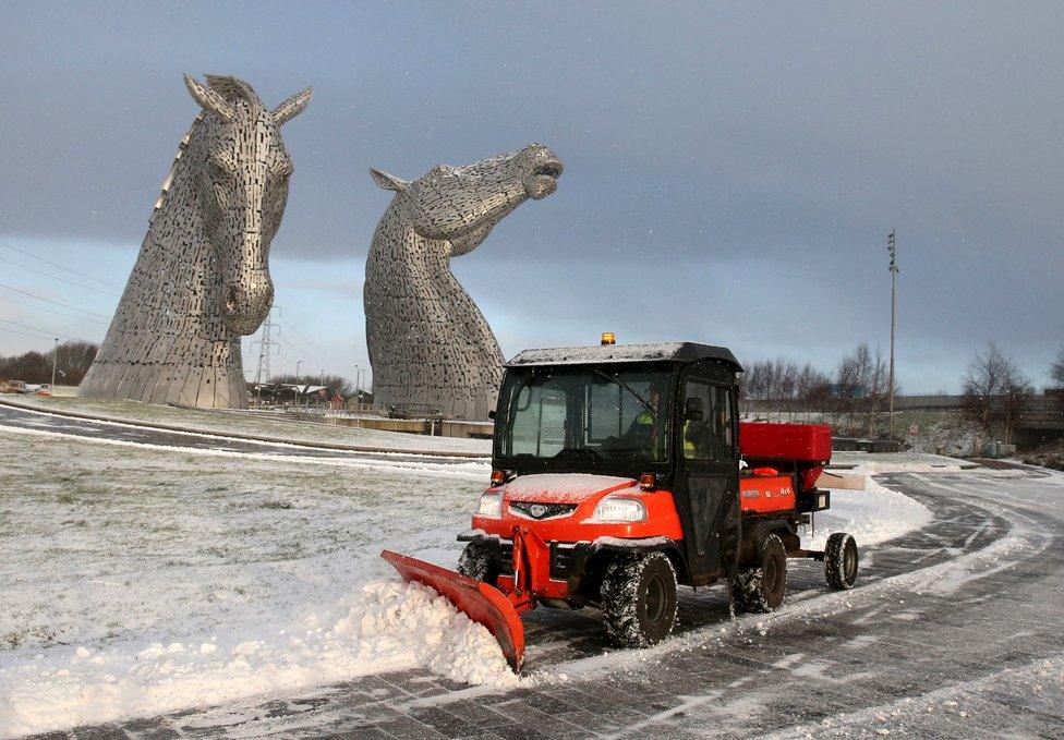 A staff member uses a vehicle to clear snow on a pathway at the Kelpies near Falkirk in Scotland, on 8 February 2021