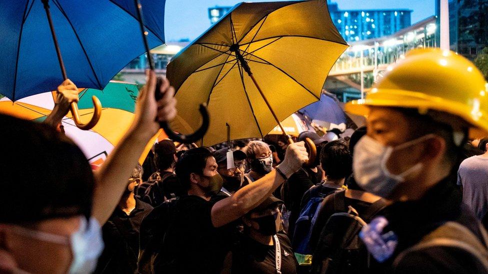 Hong Kong protesters clutch yellow umbrellas