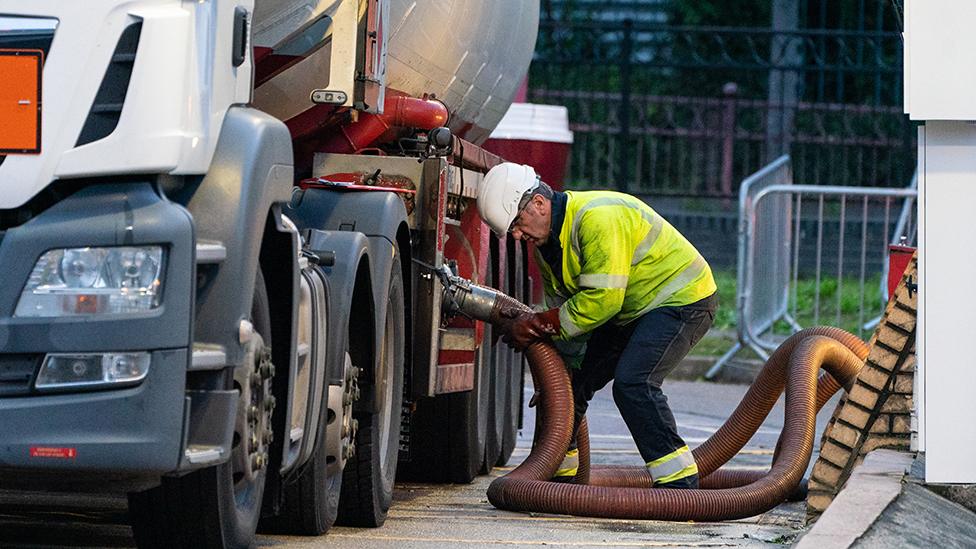 A fuel tanker driver delivers to a petrol station in London in 2021