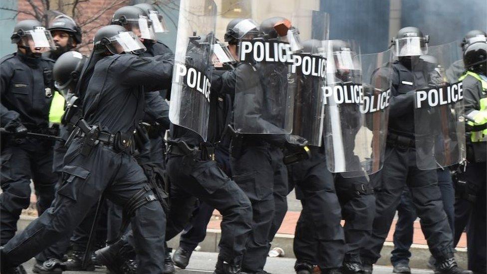 Police officers stand in line as they clash with protesters after the inauguration of President-elect Donald Trump in Washington.