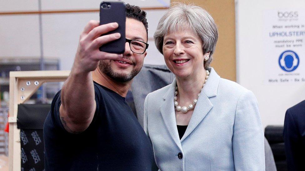 Theresa May poses for a selfie during a campaigning visit to a business in Dudley