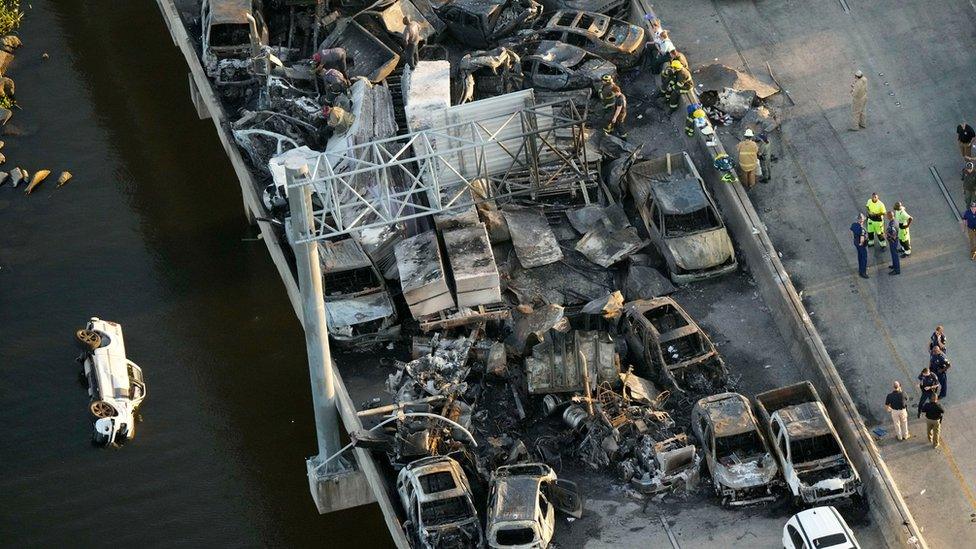 Responders are seen near wreckage in the aftermath of a multi-vehicle pileup on I-55 in Manchac, La., Monday, Oct. 23, 2023. A "superfog" of smoke from south Louisiana marsh fires and dense morning fog caused multiple traffic crashes involving scores of cars.