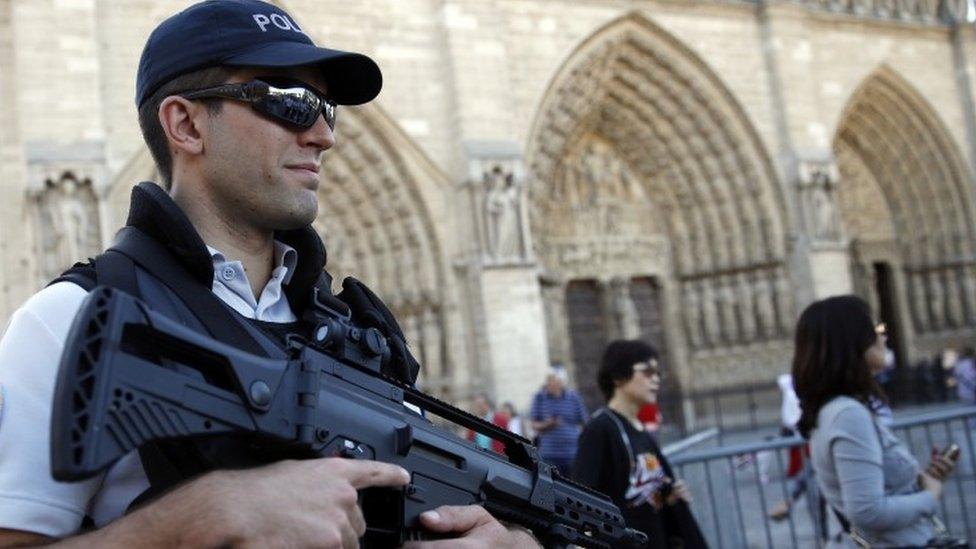 A French police officer patrols in front of Notre Dame cathedral, in Paris, Friday Sept. 9, 2016.