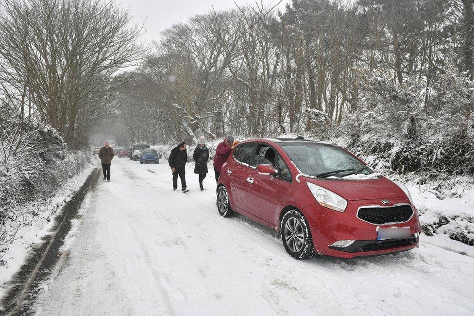 People push cars along the A30 near Land's End