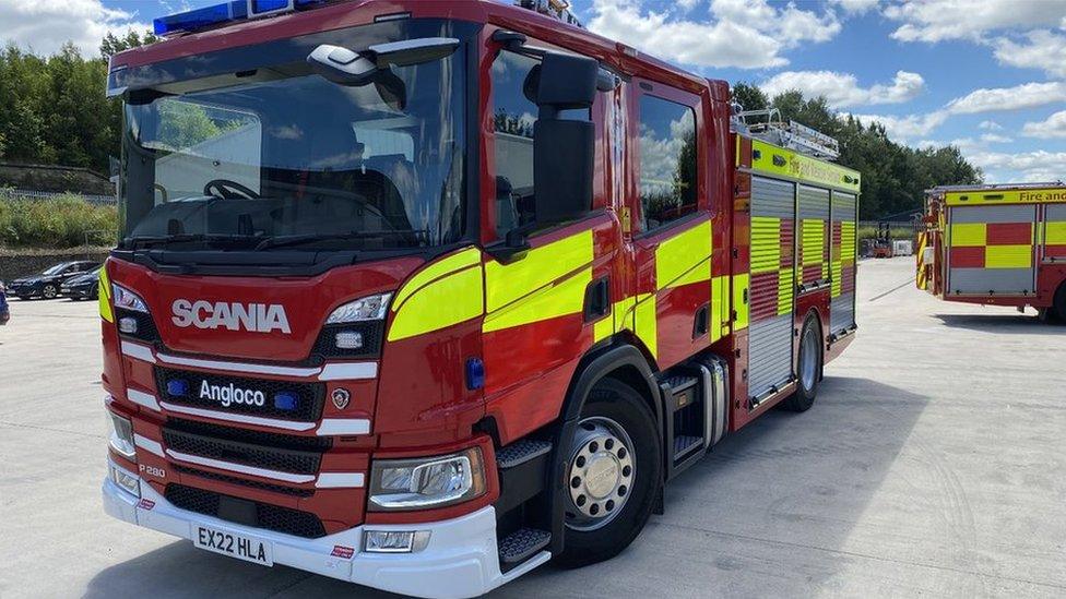 A fire engine. Red and yellow and it is parked