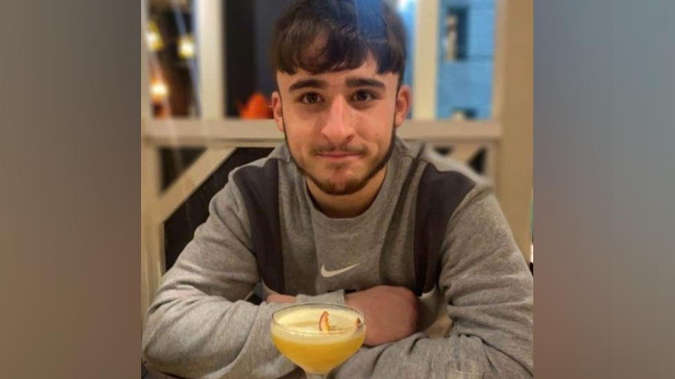 Owen Dunn sitting in a cafe with a drink in front of him