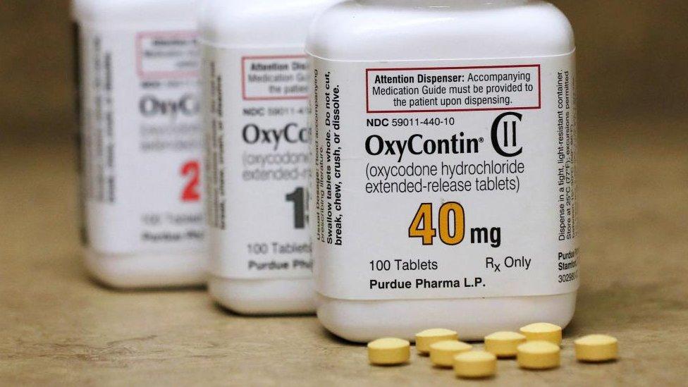 A jar of OxyContin tablets on a table