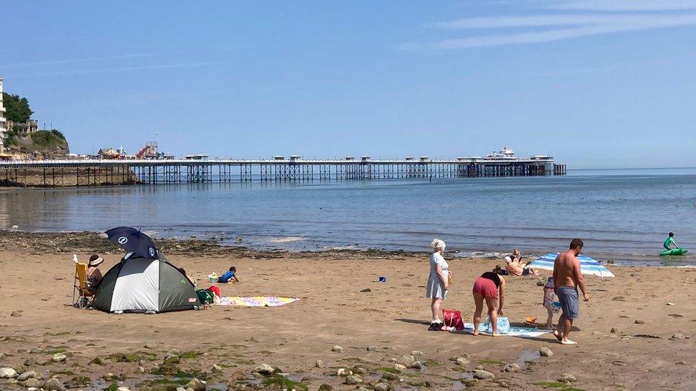 pobl ar y traeth yn Llandudno