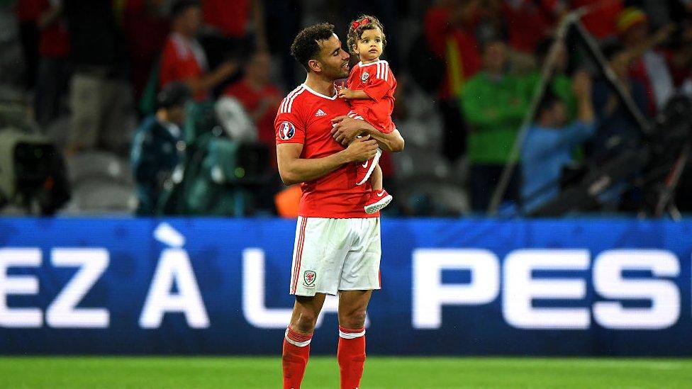 Hal Robson-Kanu of Wales celebrates his team's win with his daughter