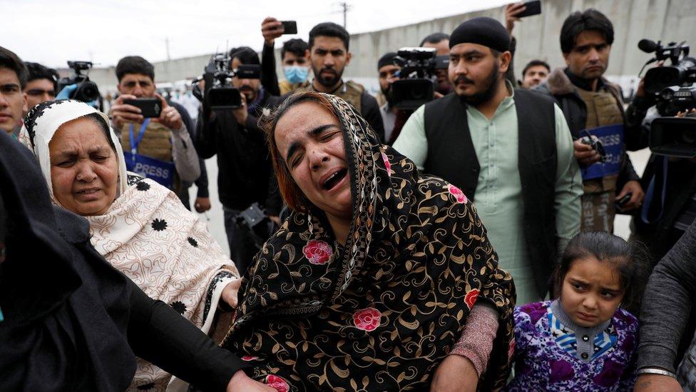 An Afghan Sikh woman grieves for her relatives near the site of an attack in Kabul, Afghanistan March 25, 2020