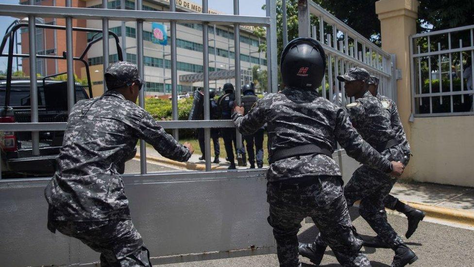 Police scramble to enter the ministerial premises after a friend of Orlando Jorge Mera shot and killed him in his office