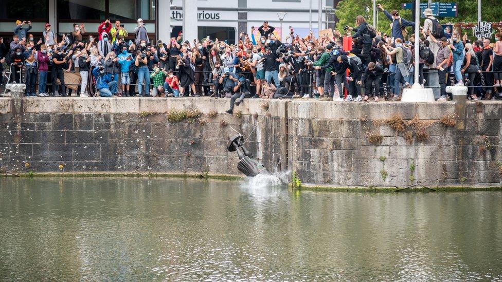 The statue of Edward Colston falls into the water after protesters pulled it down and pushed into the docks,