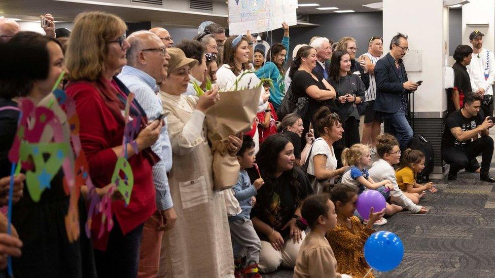 Families wait to be reunited as travellers arrive on the first flight from Sydney,