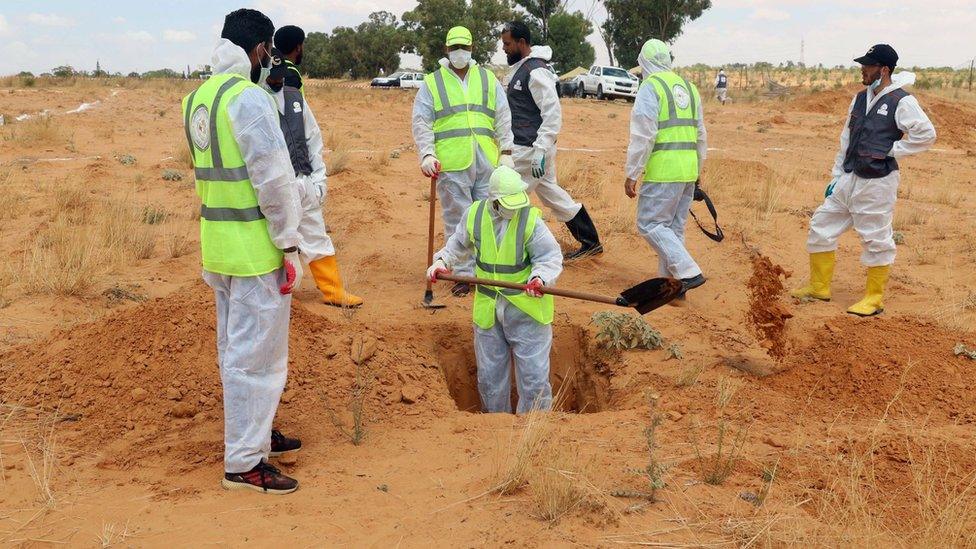 Six Libyan experts search for human remains during the exhumation of mass graves in Tarhuna, south-east of Tripoli, Libya -23 June 2020