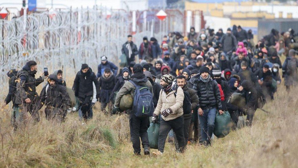 A group of refugees head to a tent camp on the Belarusian-Polish border