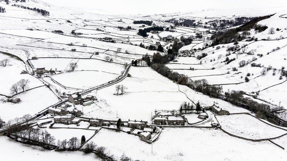 Snow covers fields and farms