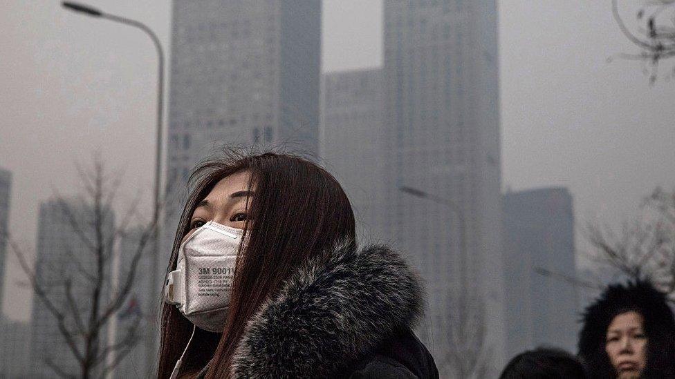 Woman wears mask due to pollution in Beijing. 12 Dec 2016