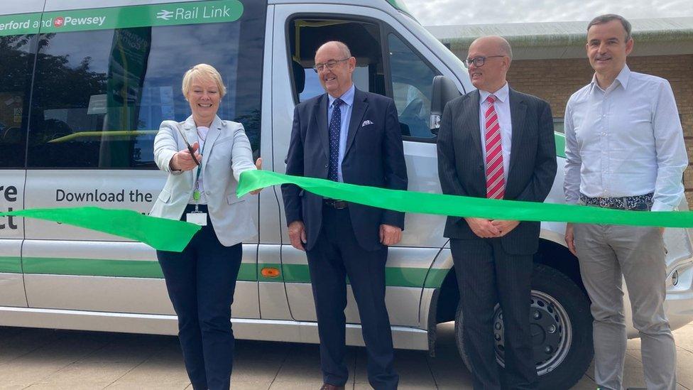 Four people and a ribbon being cut