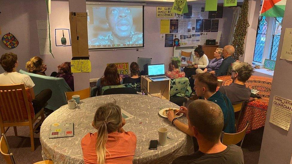 People at the community centre watching a film on a projector