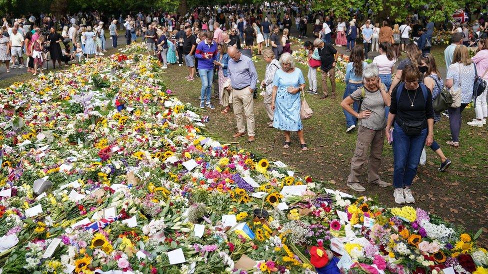 Members of the public view floral tributes in Green Park, near Buckingham Palace