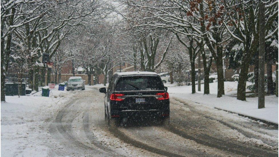 A car driving on a snowy street in Toronto