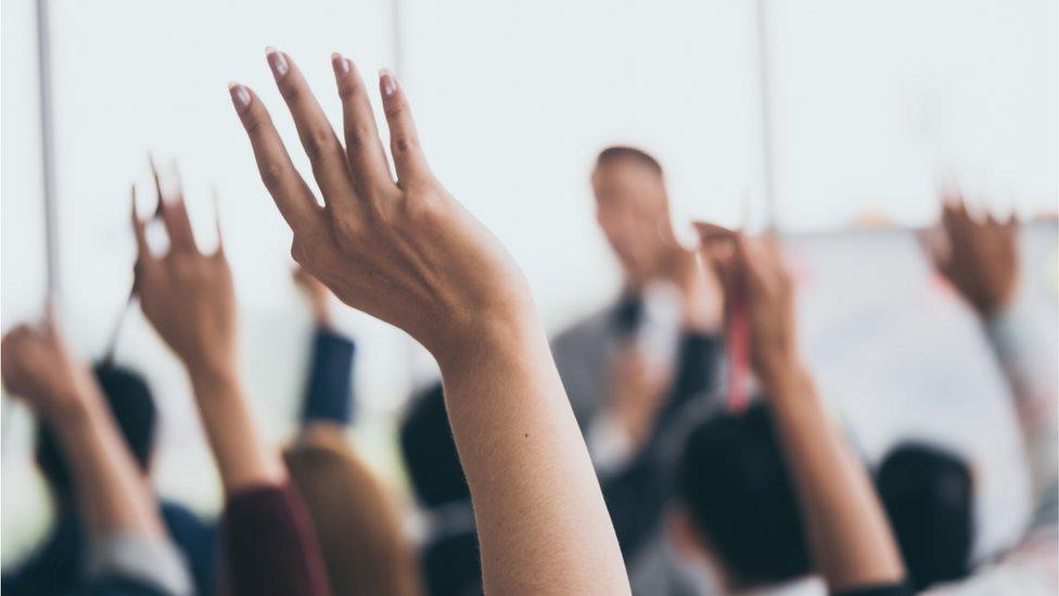 Audience raising hands up