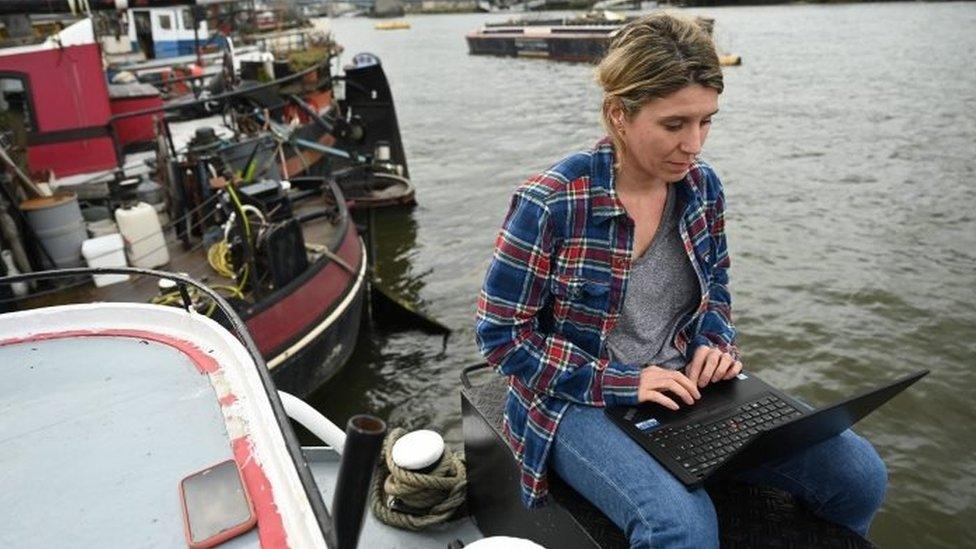 A woman working from her houseboat home