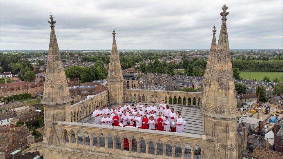 The St John's choir performs on the top of the chapel's tower