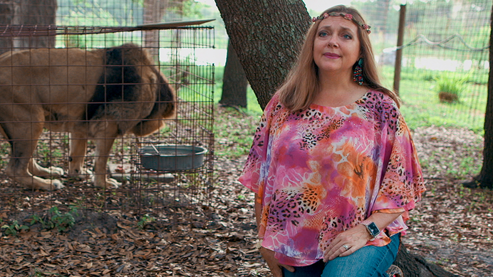 Carole Baskin and a lion in a cage