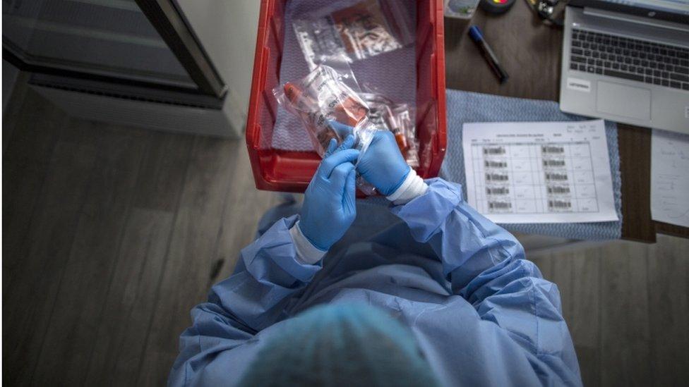 A member of the medical team collects samples of Covid19 at a drive-through testing centre in Dubai