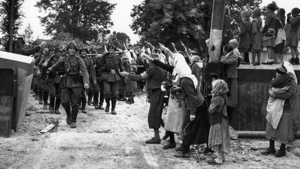 Wehrmacht soldiers entering Czechoslovakia in 1938 as locals salute