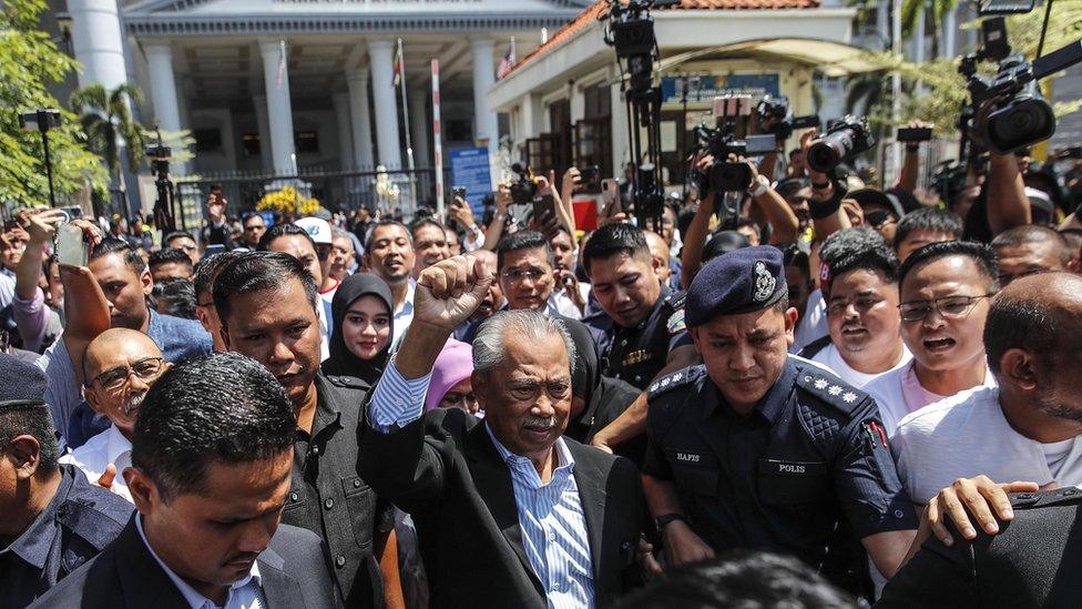 Former PM Muhyiddin Yassin is surrounded by press and crowds upon leaving the Kuala Lumpur court after his hearing on Friday