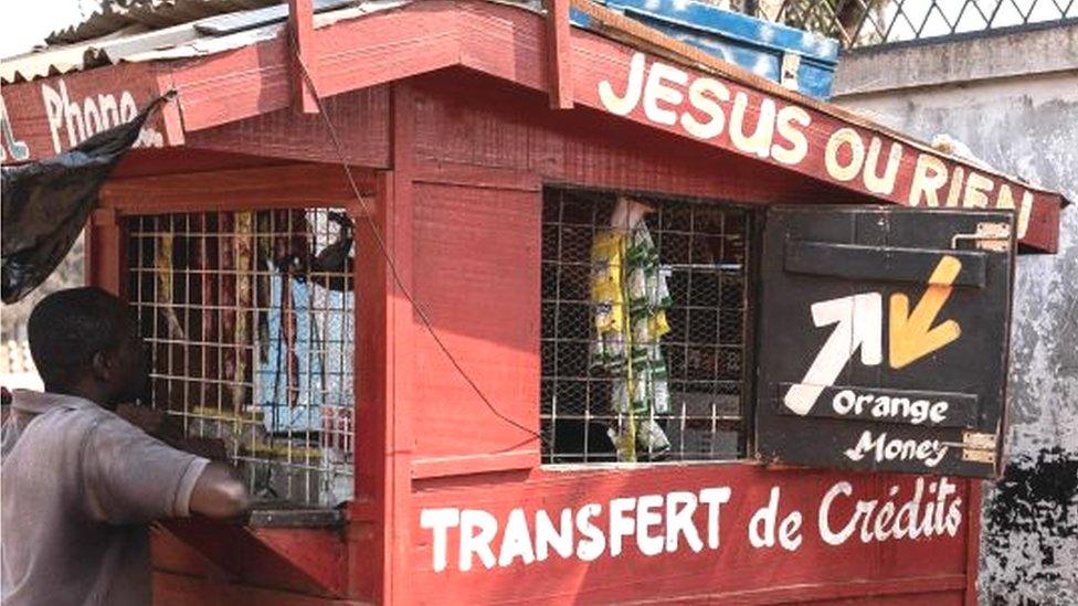 A customer makes a money transfer at an Orange Money shop in downtown Bangui on january 18, 2023.