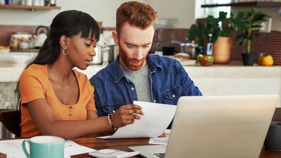 Stock image of a couple looking paperwork at home