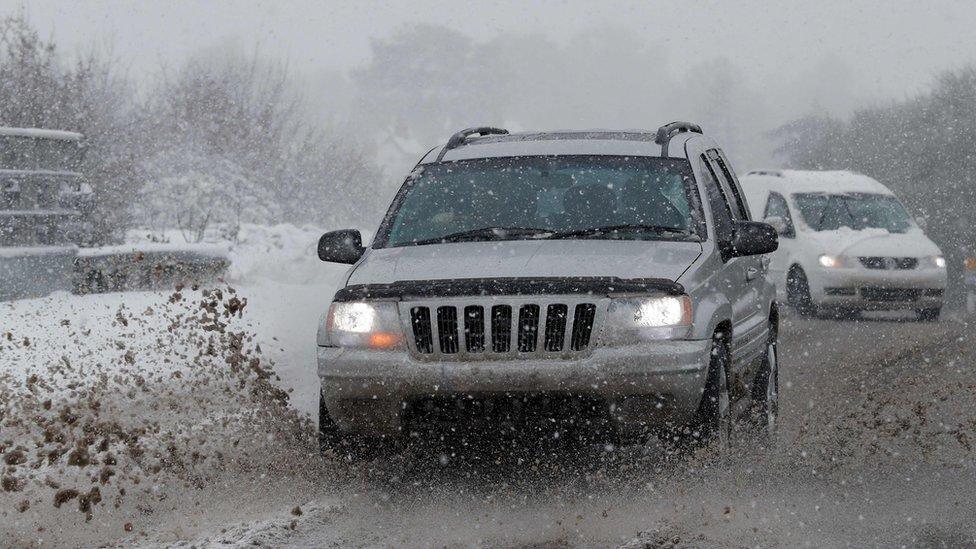 Cars are driven through snow and slush near Chievely, Berkshire.