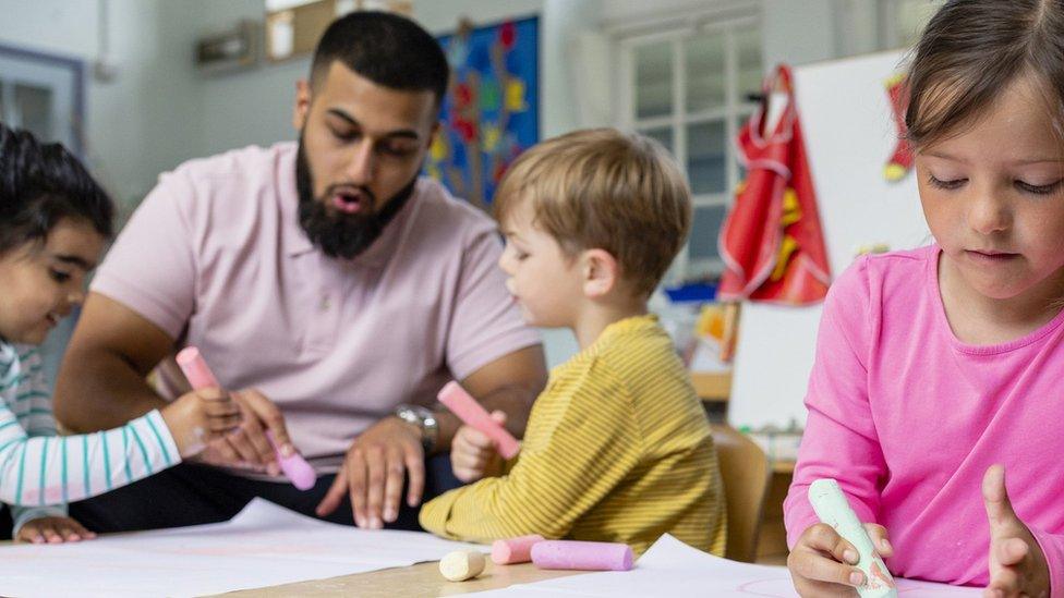 Primary school students sitting in an art classroom being taught by a teacher in the North East of England