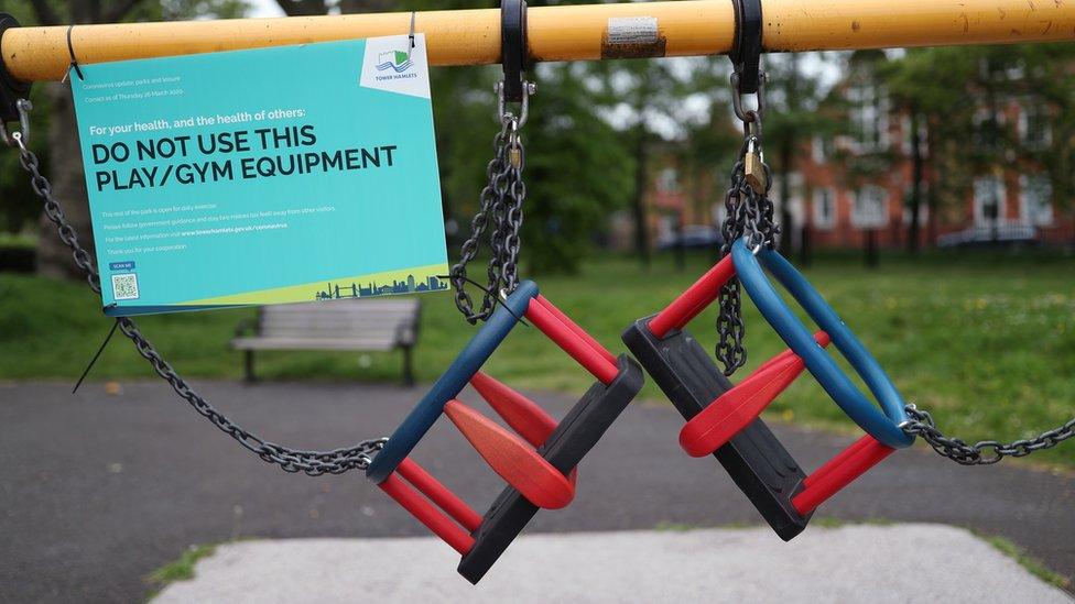 Swings tied up with a sign saying do not use this play/gym equipment