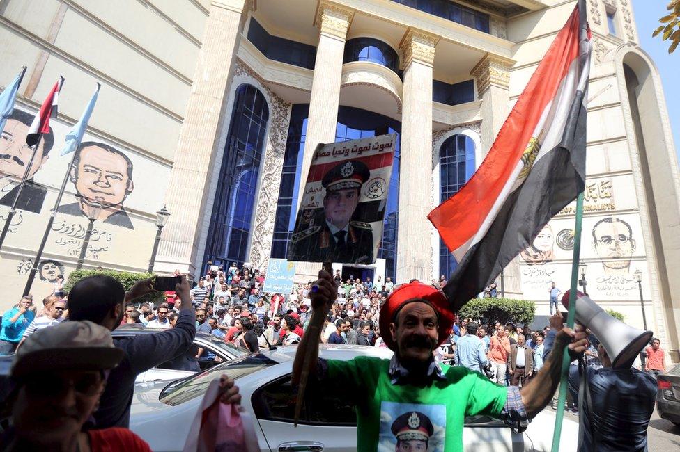 Supporter of President Abdul Fattah al-Sisi stands in front of anti-government protesters, outside the Egyptian journalists' union building in Cairo (15 April 2016)