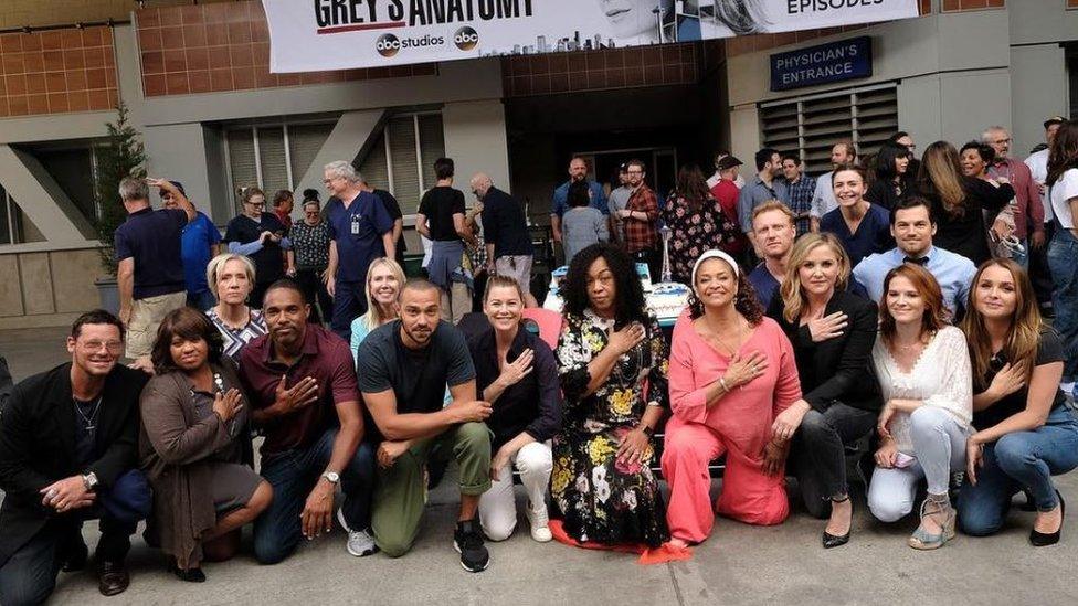 The cast of Grey's Anatomy kneeling