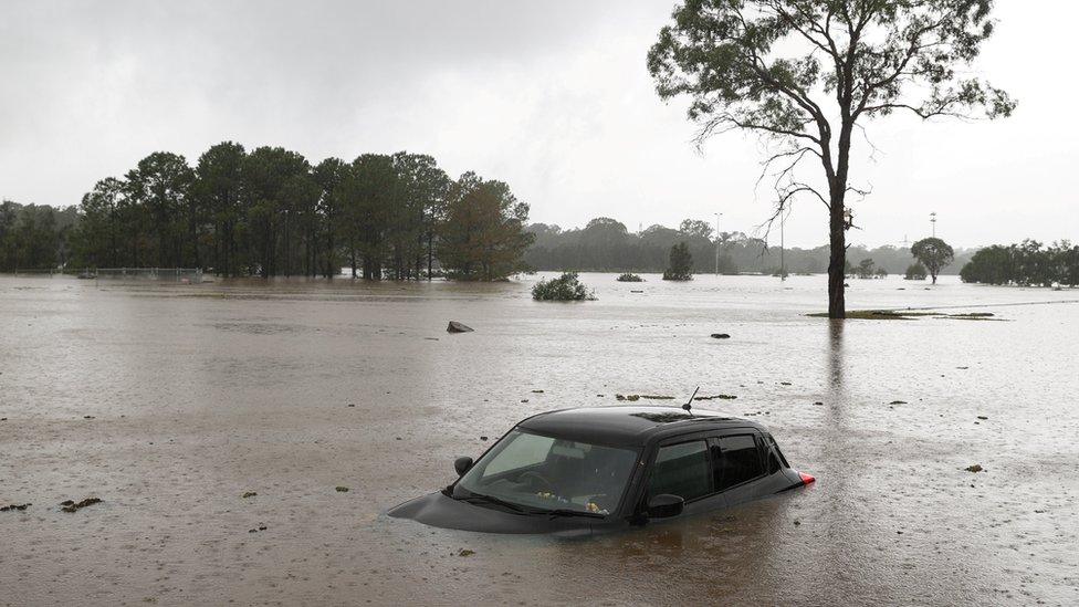 A partially submerged car is seen abandoned in floodwaters in the suburb of Windsor as the state of New South Wales