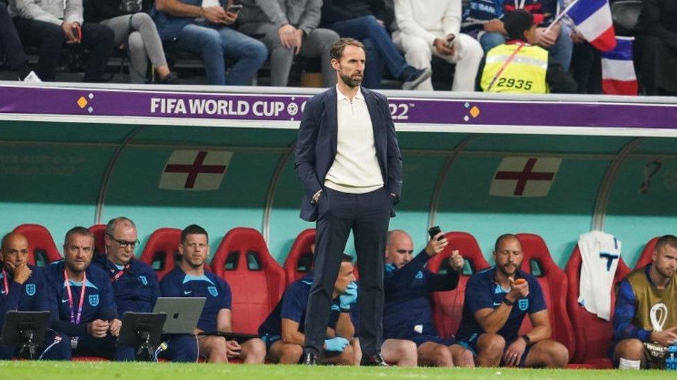 Gareth Southgate standing in front of the England dugout during England's World Cup quarter-final against France