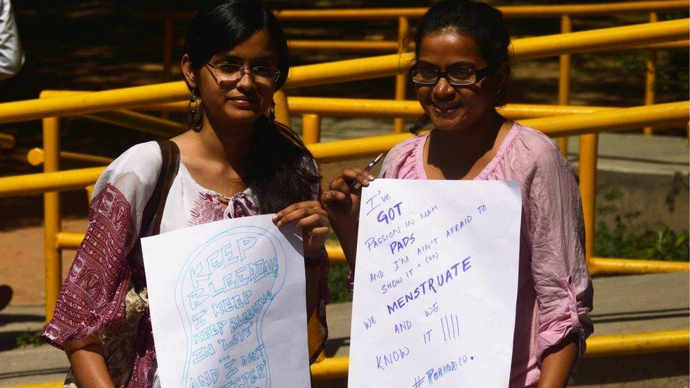 Women holding #HappyToBleed posters