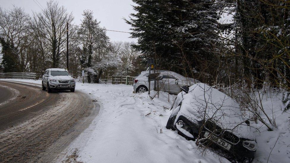 Abandoned cars in a snow filled ditch in Needham Market in Suffolk