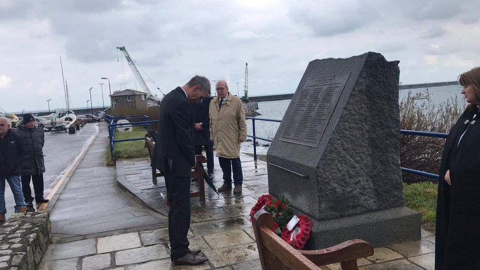 Kevin Gentle laying a wreath in front of Alfderney memorial