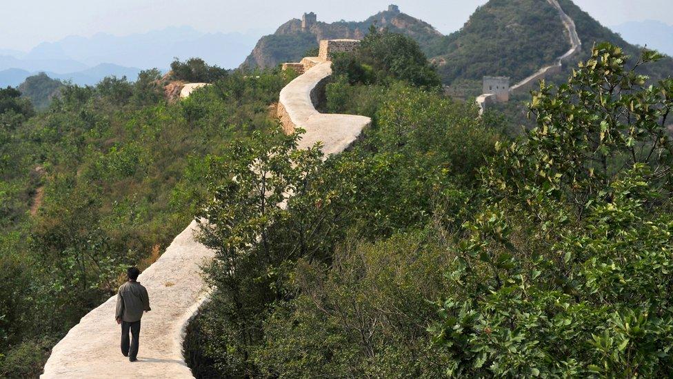 A villager walks along the long, smooth path of the repaired section