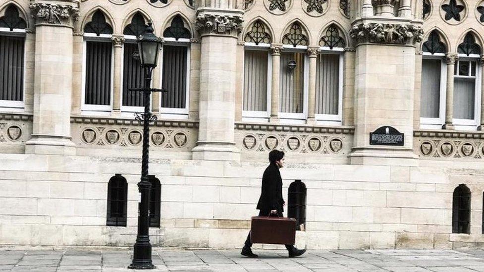 Actor Tom Burke walking past the Guildhall