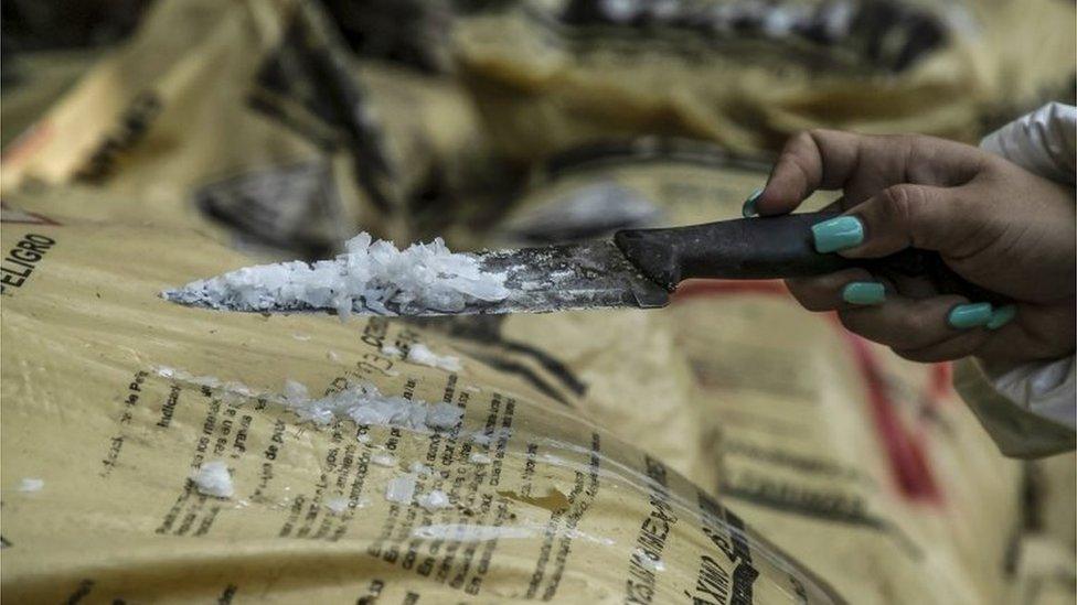 A Sinaloa state police officer works during the dismantle of one of the three clandestine laboratories producers of synthetic drug, mainly methamphetamine in El Dorado, Sinaloa state, Mexico on June 4, 2019