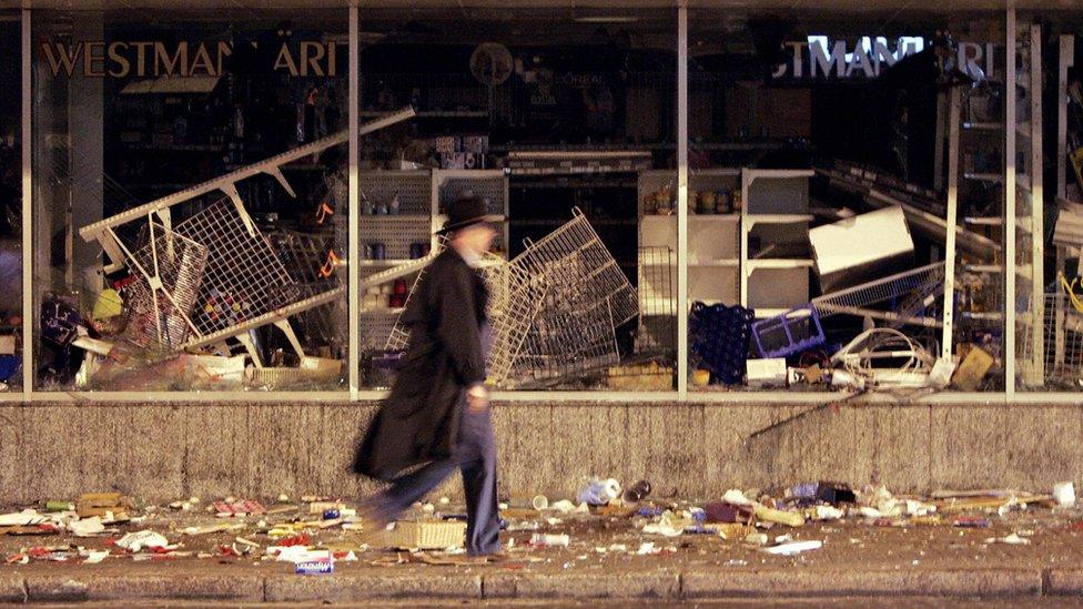 A picture taken 28 April 2007 shows a man passing by a destroyed shop after two days of riot in the center of Tallinn, after Estonian authorities took measures to remove the "Monument to the Liberators of Tallinn" - an homage